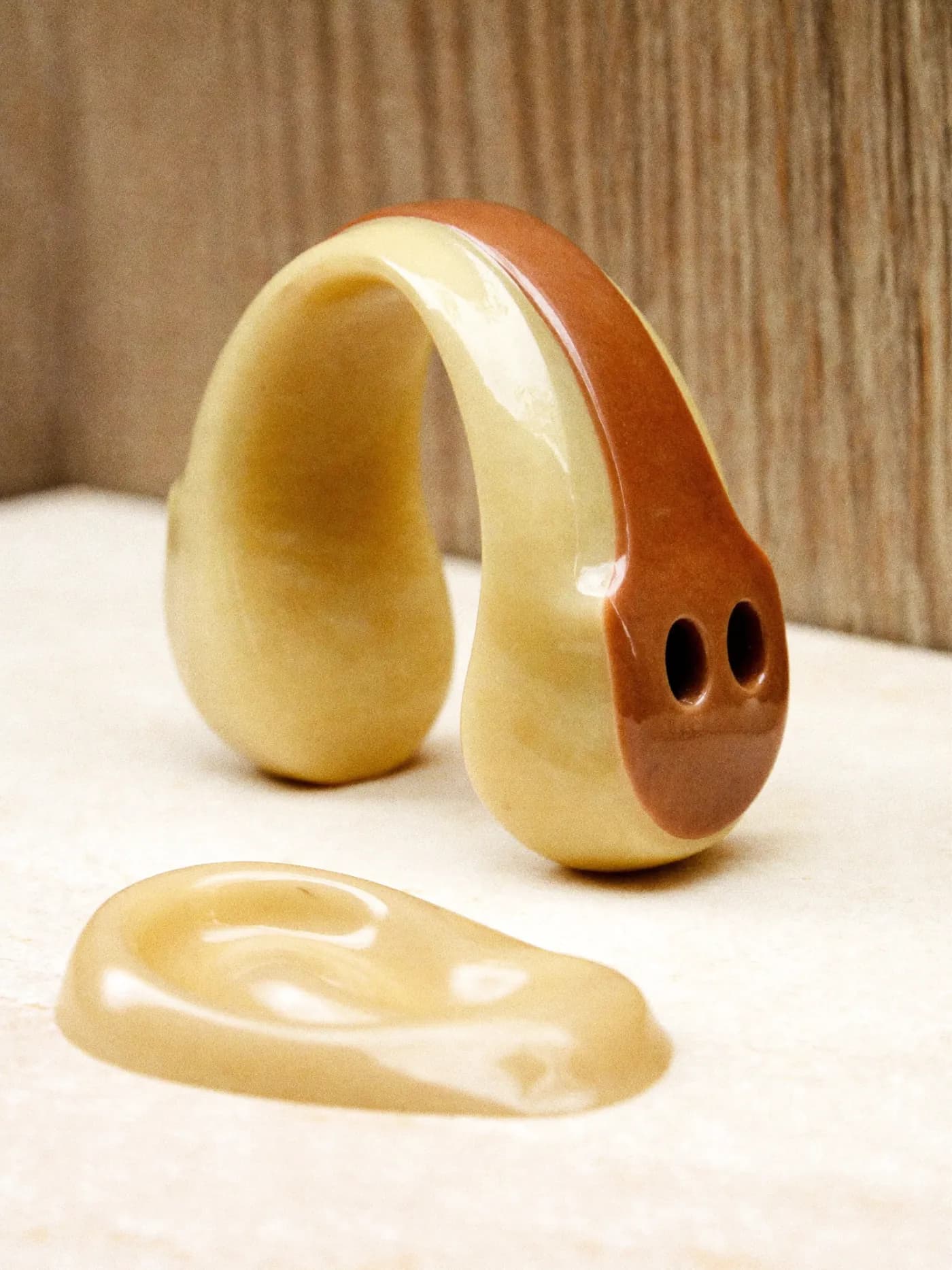 Une protection auditive sur mesure et une empreinte d’oreille posées sur du marbre clair.